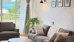 A living room with a sofa, armchairs, a round coffee table, a potted plant, and a window with curtains. - Executive 2 bdrm Apartment Meru, Mt. Kenya region (Meru County)