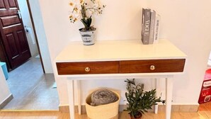 A white desk with two drawers, a potted plant, a rolled-up blanket, and a book titled 'VOLEO'. - Executive 2 bdrm Apartment Meru, Mt. Kenya region (Meru County)