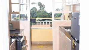 A kitchen with a view of a balcony, a stove, and cabinets. - Executive 2 bdrm Apartment Meru, Mt. Kenya region (Meru County)