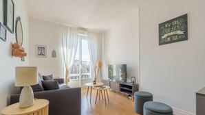 Ein modernes Wohnzimmer mit einer Couch, einer Lampe, einem Fernseher und einem Couchtisch.