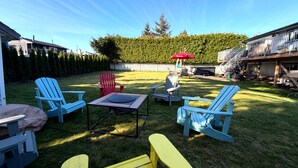 A backyard with outdoor seating, a barbecue area, and a staircase leading to a deck. - Near Vancouver: Backyard Cinema + Game (Delta)