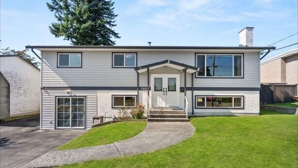A two-story house with a front entrance, a garage, and a driveway. - Near Vancouver: Backyard Cinema + Game (Delta)