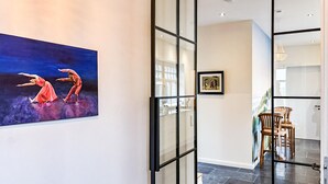 A modern interior with a glass partition, a framed artwork, and a dining area with chairs. - Cozy home in Detern with WiFi (Detern)