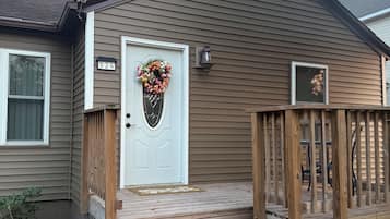 Una casa residenziale con un portone, un portico in legno e una cassetta postale.