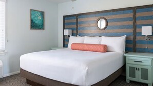 A hotel room with a large bed, a wooden headboard, two bedside tables, a round mirror, and a painting on the wall. - 2-bedroom hotel suites in terrific Anaheim with fitness room and AC (Anaheim)