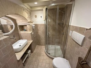 A bathroom with a glass-enclosed shower, a sink, a toilet, and a mirror. - Tower Slope b&b (Corato)