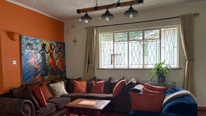 Un salon avec un canapé, une table basse et un tableau accroché au mur.