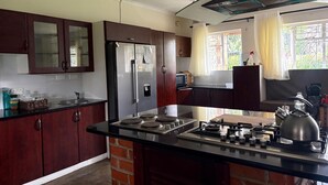 Una cucina con isola centrale, elettrodomestici in acciaio inossidabile e pensili in legno.