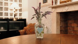 A clear view of a room with a fireplace, a table with a vase of flowers, and a television in the background. - Casa Boutique ALEGRÍA, aromas and art. (Caudete de las Fuentes)