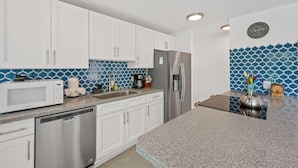 A modern kitchen with white cabinets, a stainless steel refrigerator, a microwave, and a dishwasher. - Generator! 5 mins to Magens + 15 mins to STJ ferry (St Thomas)
