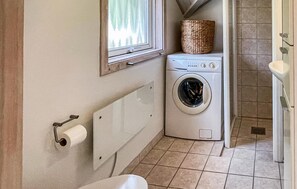 A compact laundry room with a washing machine, a window, a basket, and a toilet. - Amazing home in Rørvig with WiFi (Rørvig)