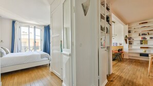 A bedroom with a bed, a wardrobe, a desk, and a bookshelf. - Boho-chic cocoon in Neuilly-sur-Seine. (Neuilly-sur-Seine)