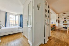 A bedroom with a bed, a wardrobe, a desk, and a bookshelf. - Boho-chic cocoon in Neuilly-sur-Seine. (Neuilly-sur-Seine)