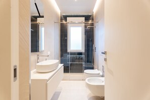 A modern bathroom with a large mirror, two sinks, a shower, and a toilet. - Solymar Sole by Monholiday (Monopoli)
