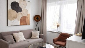 Ein modernes Wohnzimmer mit einer Couch, einem Couchtisch und einem Schreibtisch.