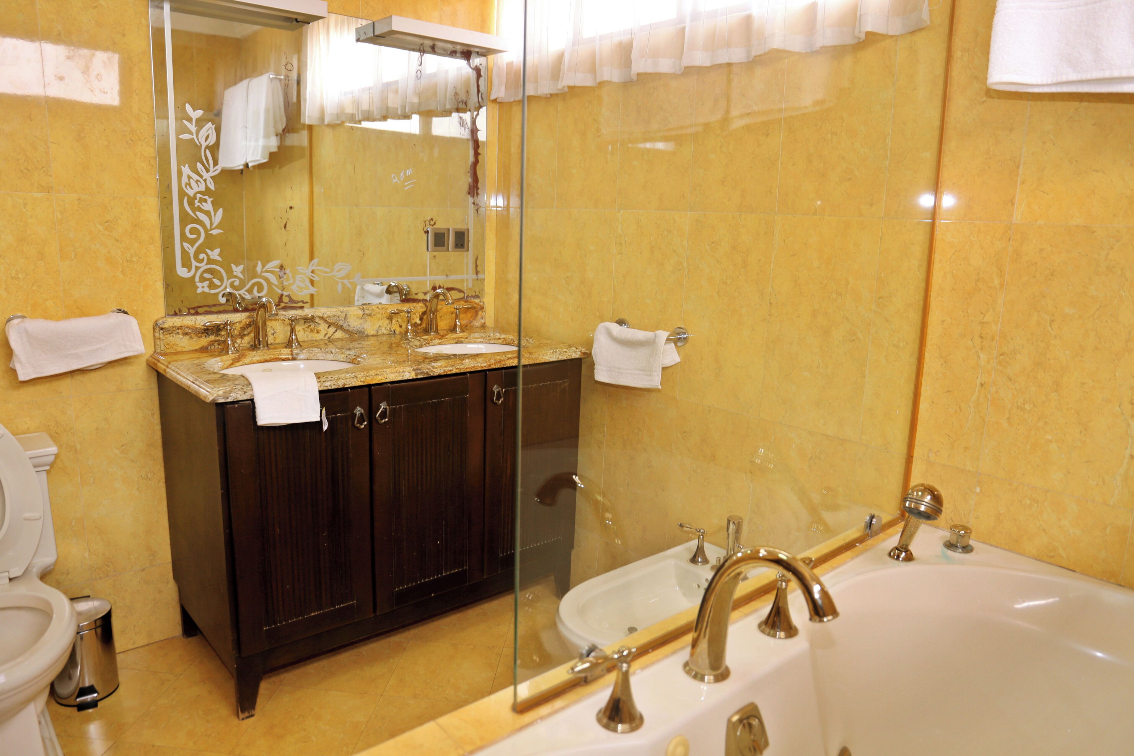 Un baño con lavamanos doble, bañera y retrete.