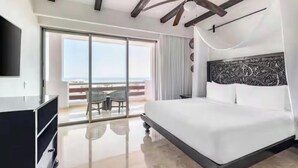 Ein modernes Hotelzimmer mit einem großen Bett, einem Deckenventilator, einem Fernseher und einem Balkon mit Blick.