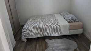 A small, neatly arranged bedroom with a bed, pillows, a rug, and a window. - Entire apartment - Angers, France (Angers)