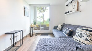 Una camera moderna con un letto, un tavolino e una porta scorrevole in vetro che dà su uno spazio all'aperto.