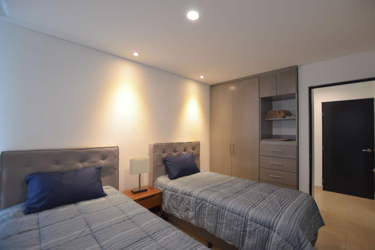 Camera da letto con due letti, un armadio e una porta.
