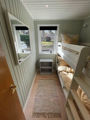 A narrow room with a bunk bed, a small window, a mirror, and a shelf. - Holiday idyll at Dejret Klit hot tub (Knebel)