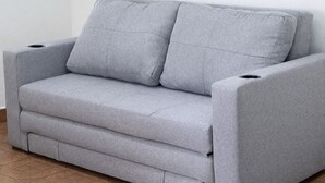 A grey sofa with armrests and a footrest, positioned against a white wall. - Casa Cruz (Brisas de Zicatela)