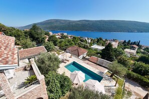 Zona residencial con piscina, casas adosadas y vista al mar.