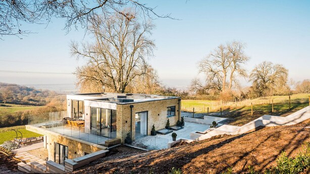 A modern house with a glass facade, a flat roof, and a patio area. - Elysian Heights - Five Bedroom Villa, Sleeps 10 (Cheltenham)