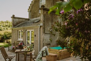 Un edificio de piedra con un patio, mobiliario exterior y una mesa de billar.