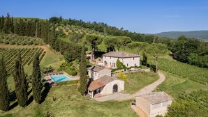 Eine Villa mit Swimmingpool, umgeben von Weinbergen und Bäumen.