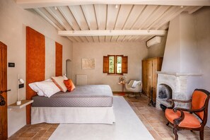 A bedroom with a bed, a chair, a fireplace, and a window. - Casale Eleganza - Five Bedroom Villa, Sleeps 10 (San Gimignano)