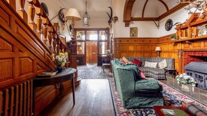 A traditional interior with a staircase, wooden furniture, and a fireplace.