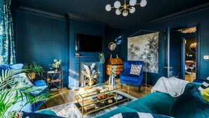 A living room with a blue sofa, a coffee table, and a painting on the wall.