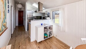 Eine kleine Küche mit Kühlschrank, Herd und Fenster.