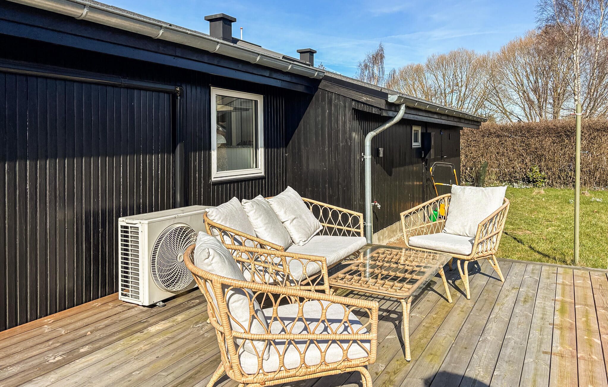 A black building with a window and a fan on the deck.