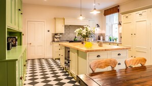 A kitchen with a checkered floor, a coffee machine, and a vase with flowers on the island. - Freya House - Nine Bedroom Villa, Sleeps 18 (Nairn)