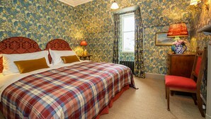 A room with a large bed, a wooden chair, and a window with curtains. - Freya House - Nine Bedroom Villa, Sleeps 18 (Nairn)