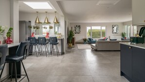 A modern kitchen with a dining area, a sofa, and a large window. - Clarence Estate - Eight Bedroom Villa, Sleeps 20 (Woodnesborough)