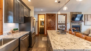 A kitchen with granite countertops, stainless steel appliances, wooden cabinets, and pendant lighting. - True Blue 92 at Eagles Nest - 3 King Suites, Deck Fire Table, Firepit (Banner Elk)