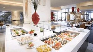 Monipuolinen buffet, suuri maljakko ja moderni sisustustyyli.