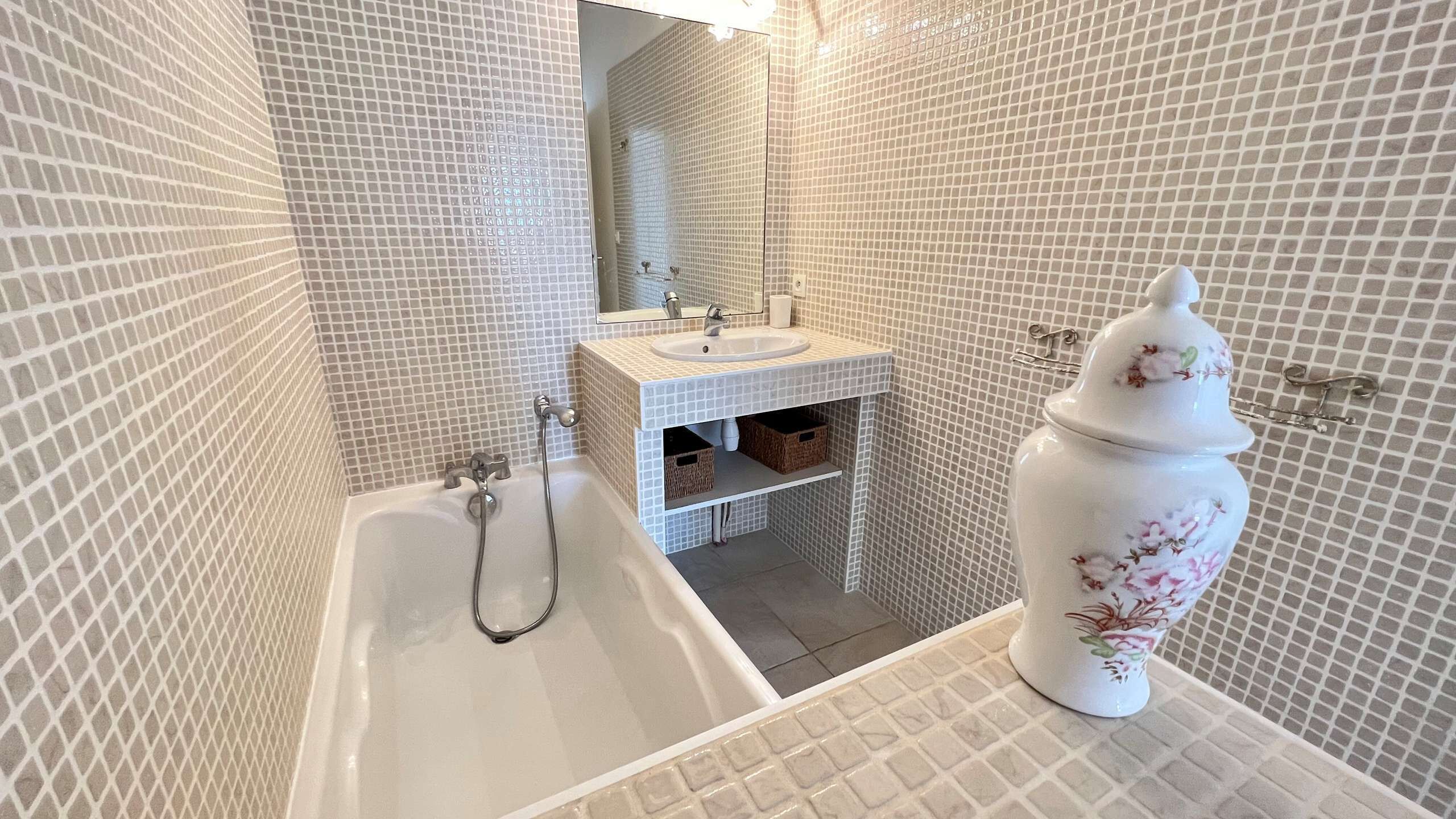 Un baño con una bañera blanca, un lavabo y un espejo.