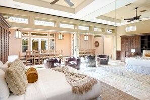 Une chambre d’hôtel spacieuse, dotée d’un grand lit, de plusieurs coins salon et offrant une vue sur la terrasse extérieure.