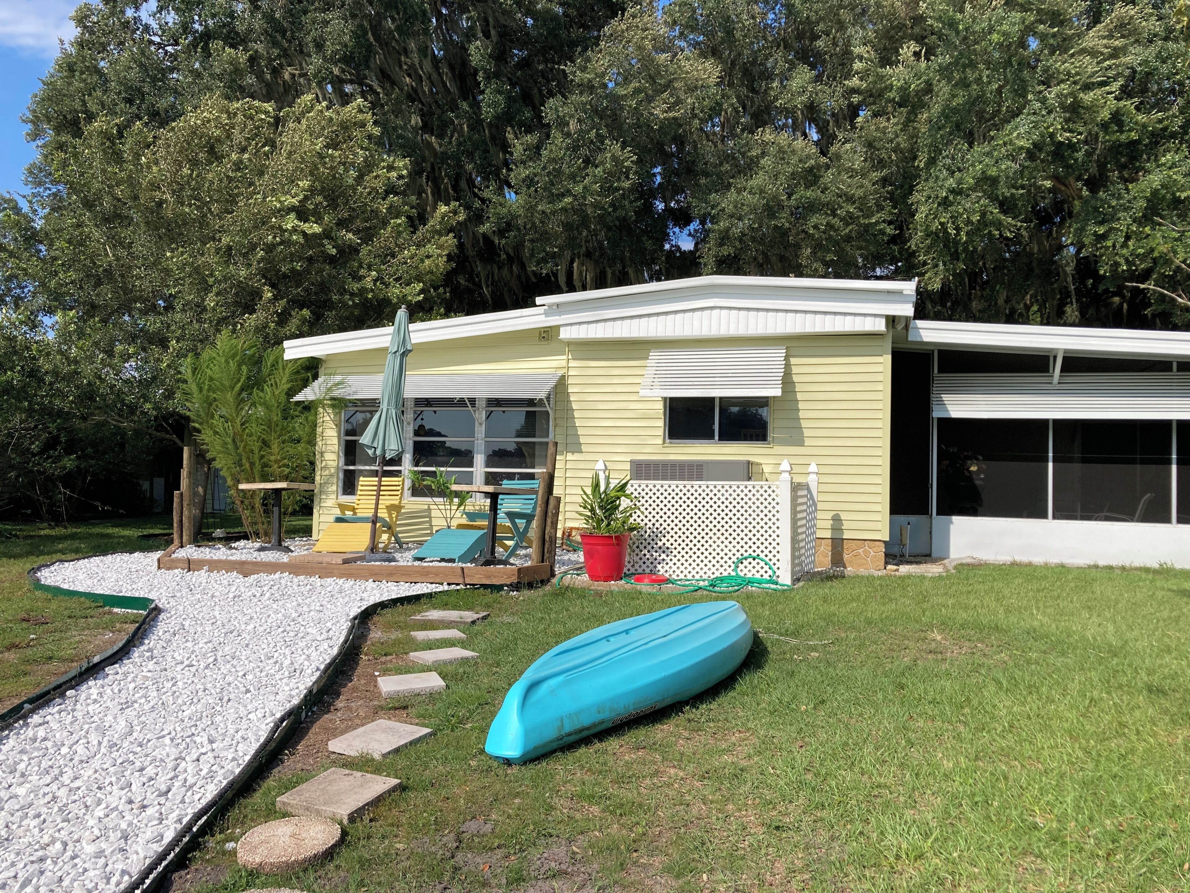 A house with a patio, a boat, and a garden.
