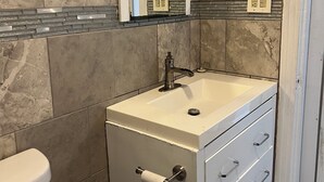 A bathroom with a sink, mirror, and toilet. - Cozy Apartment Little Rock Pets Welcome (Little Rock)