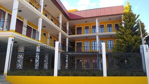 A multi-story building with balconies, a gated entrance, and a clear sky. - HOTEL CONSTITUCION (Mineral del Monte)