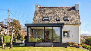 A modern two-story house with a large glass front, a chimney, and a small balcony. - Cozy home in Erquy with WiFi (Erquy)