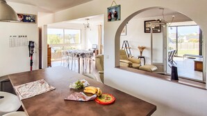 A spacious dining area with a long table, chairs, and a view of the outdoors. - Cozy home in Erquy with WiFi (Erquy)