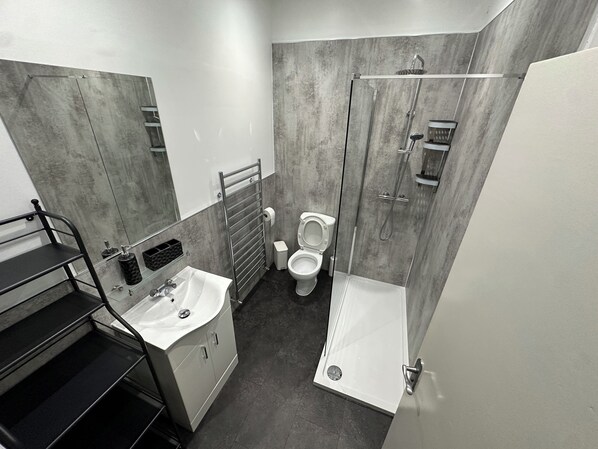 A modern bathroom with a toilet, sink, and shower.