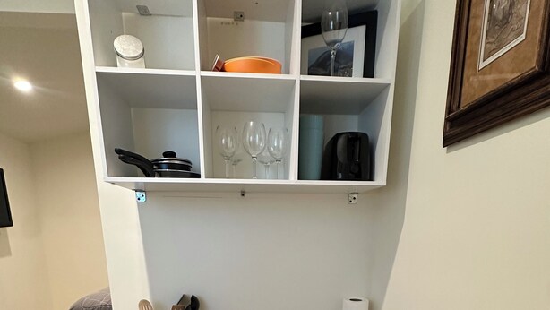A dining area with a wooden table, black chairs, a white shelf with kitchenware, and a framed picture on the wall. - Cozy 1-bedroom guest house studio in marvelous Lancaster (Lancaster)
