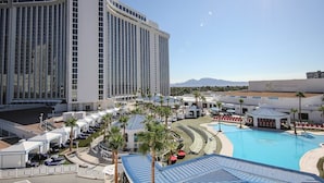Ett semesterhotell med en stor pool, palmer och en hög byggnad med skylten ”WESTGATE”.